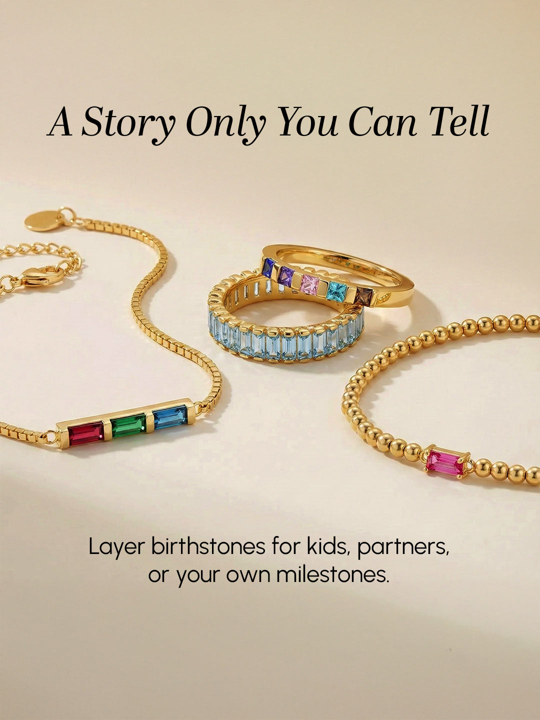 Gold jewelry with colorful birthstones on a beige background