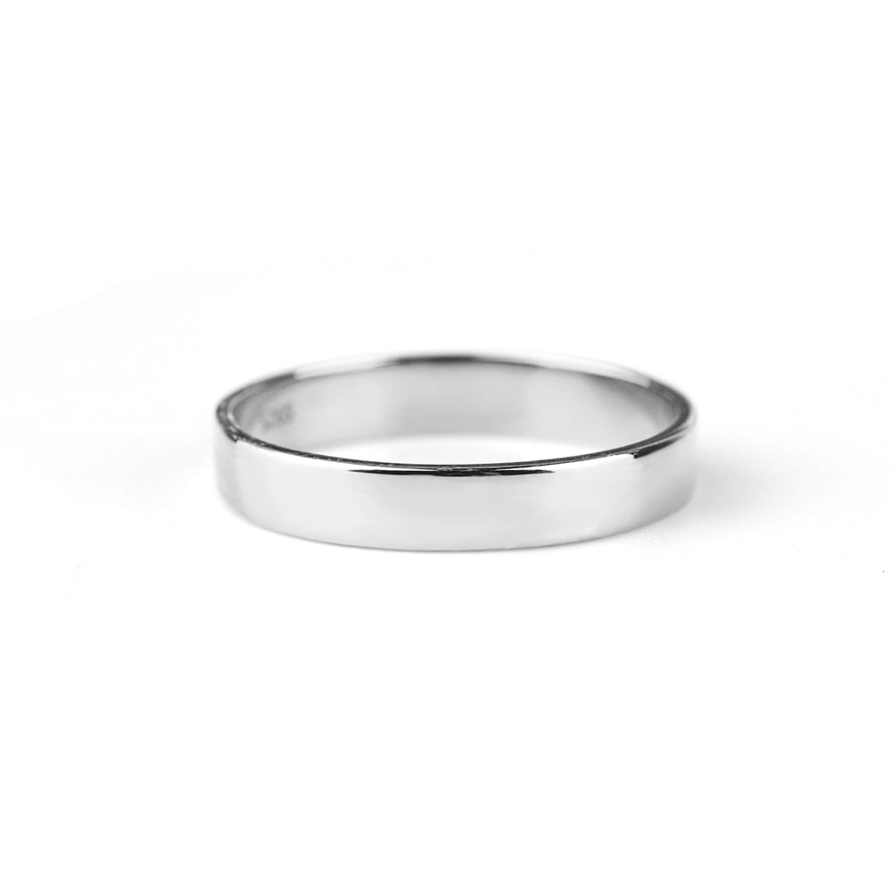 A gold-colored metal band ring with a smooth, flat surface against a white background.