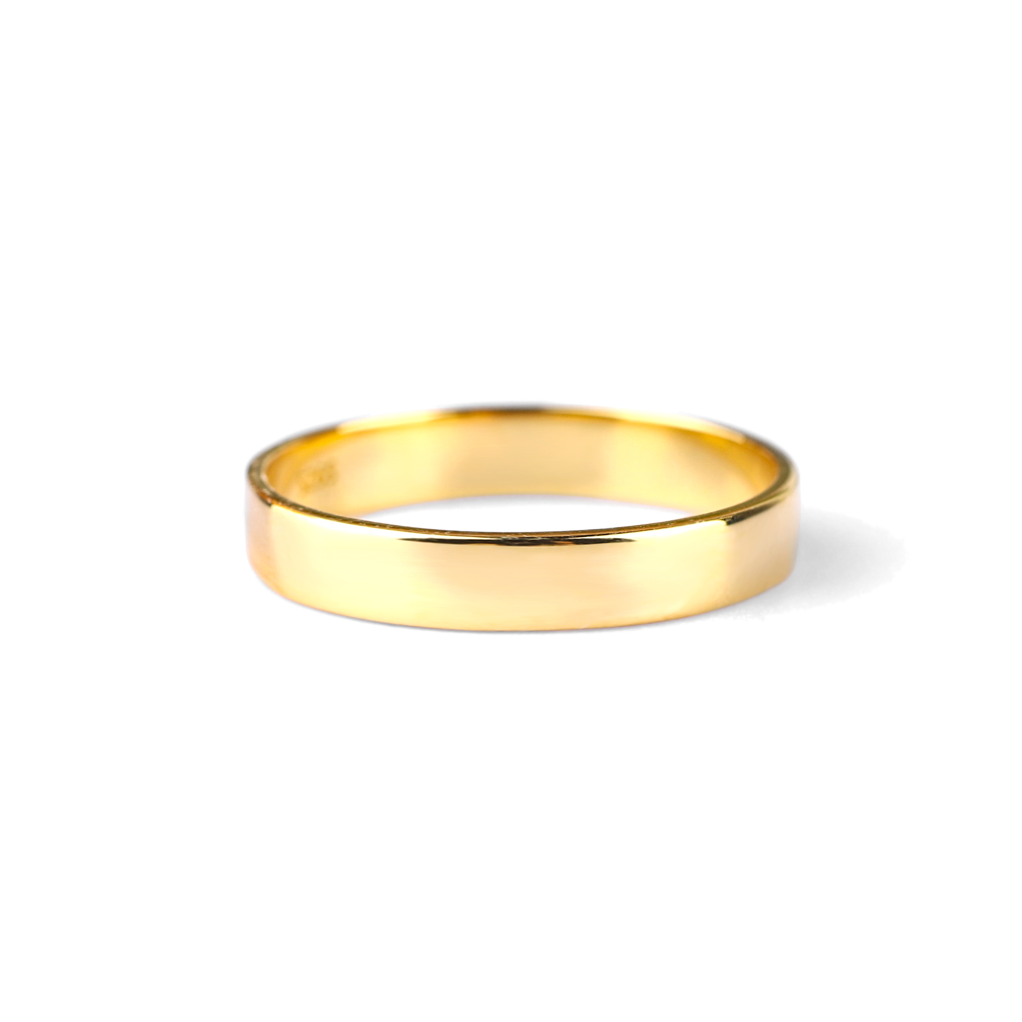 A gold-colored metal band ring with a smooth, flat surface against a white background.