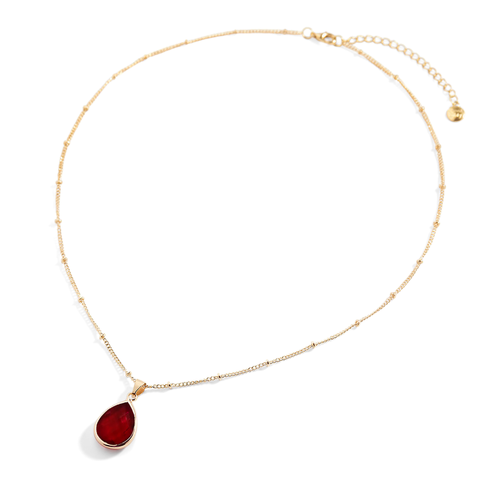 Gold necklace with a red teardrop pendant on a white background