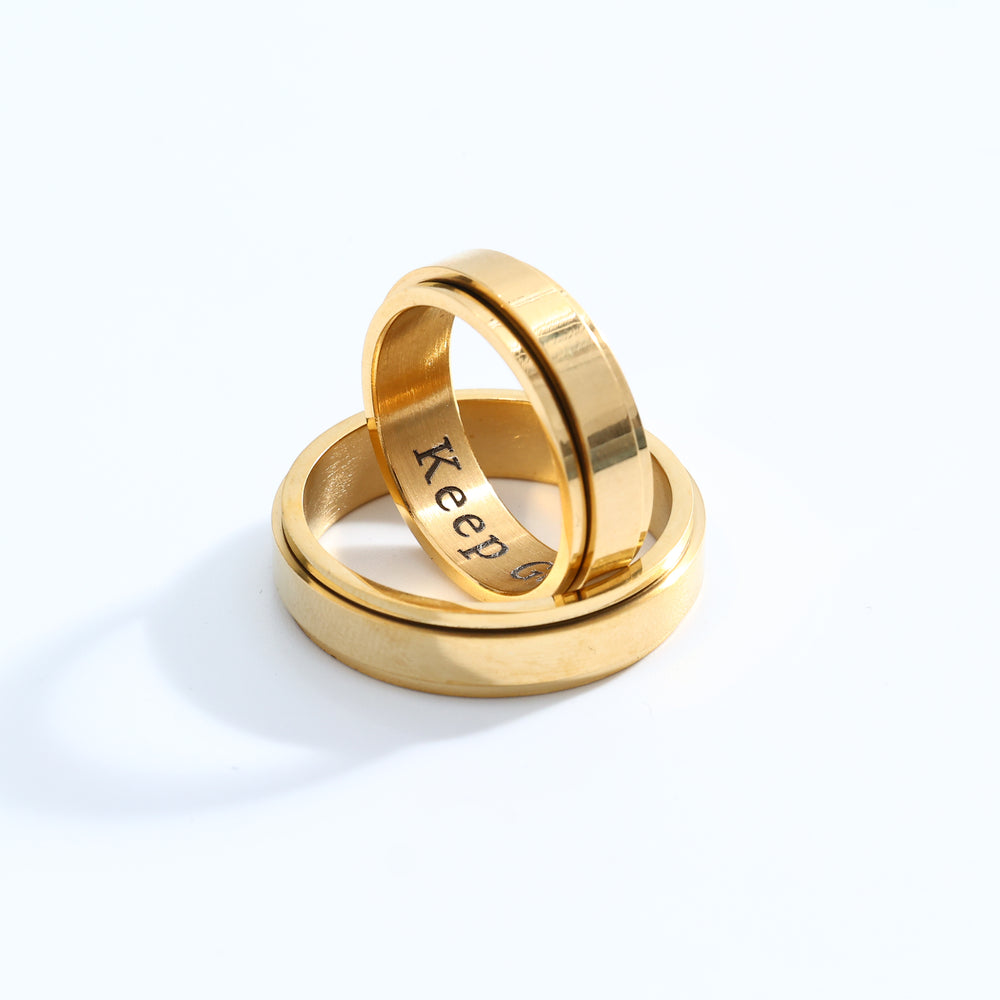 Two gold rings stacked on a white background