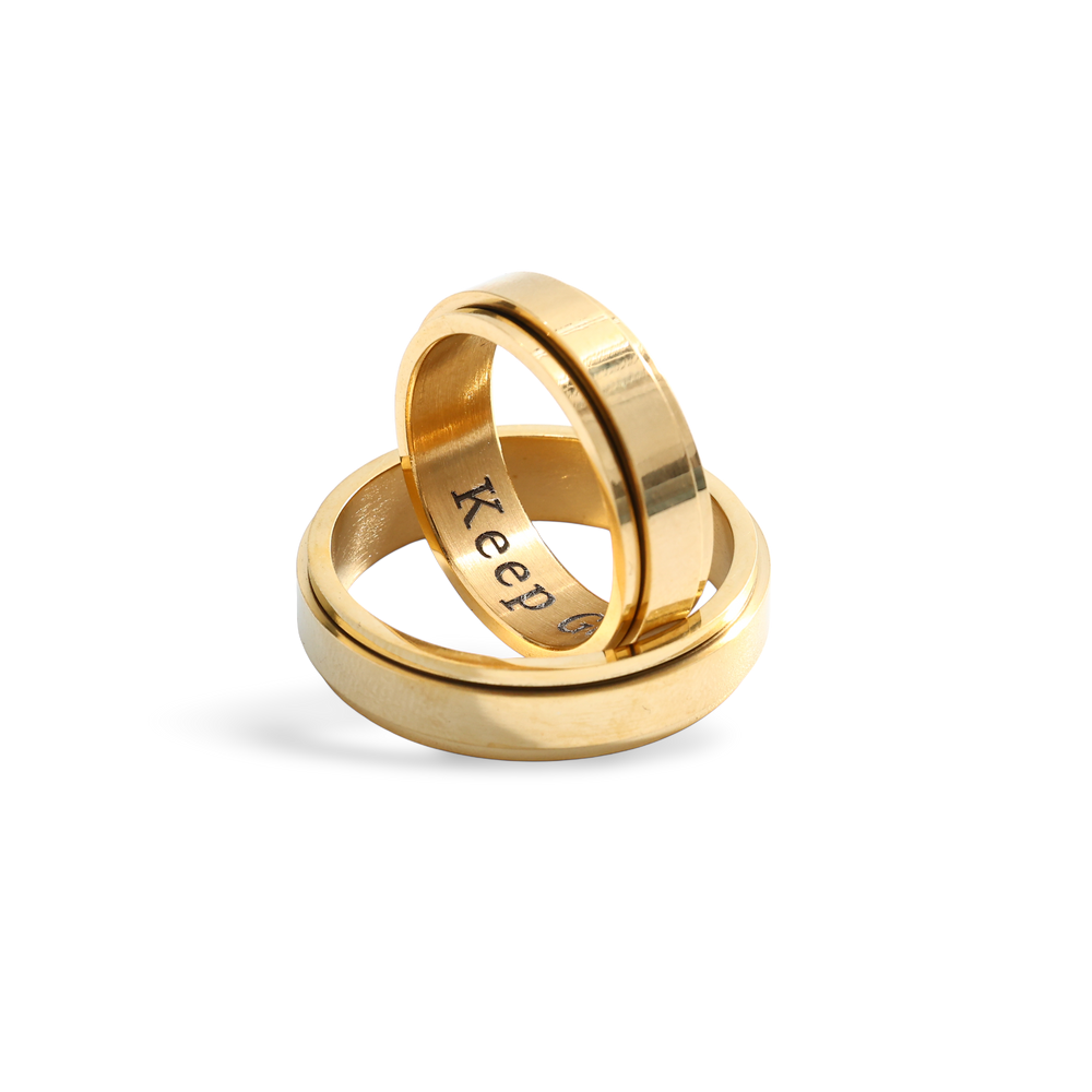 Two gold rings stacked on a white background