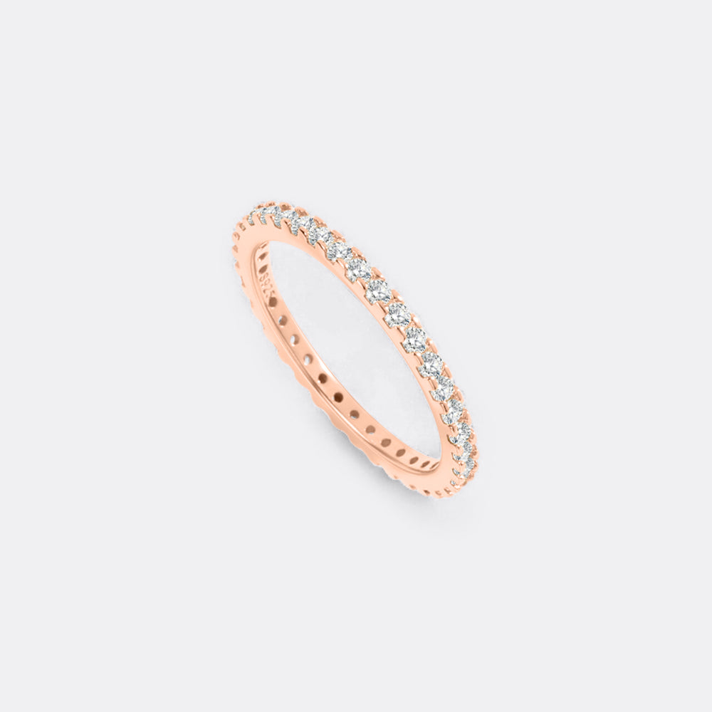 Rose gold ring with small diamonds on a light gray background