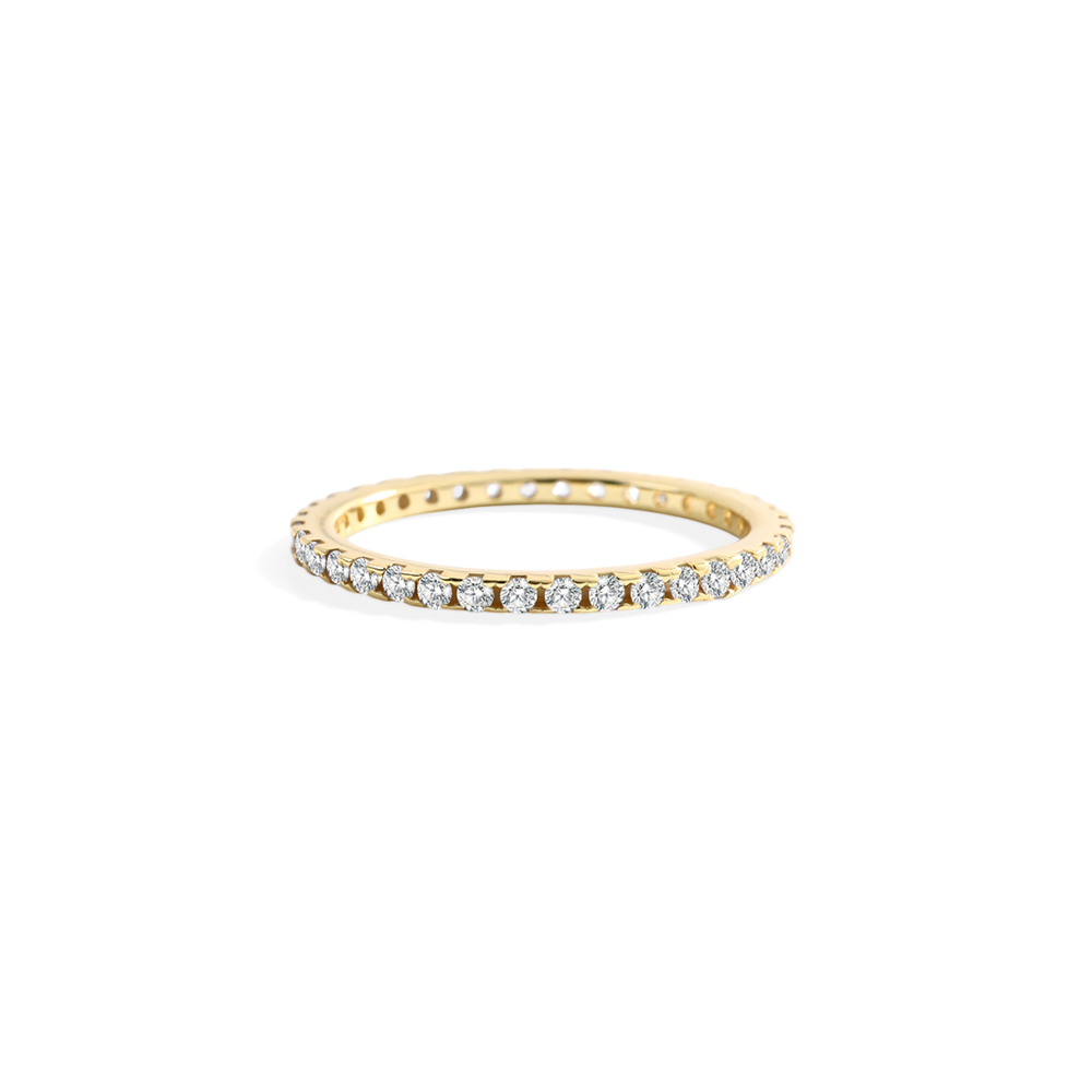 Gold ring with small diamonds on a light gray background