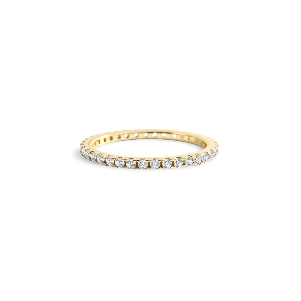 Gold ring with small diamonds on a light gray background