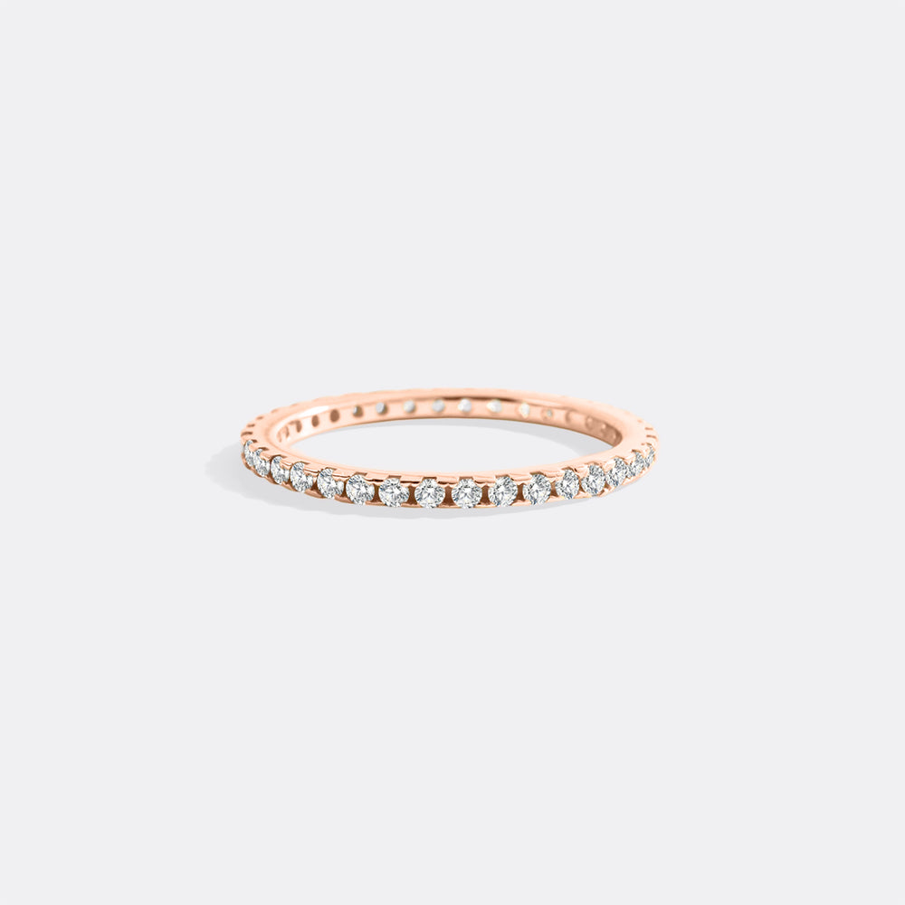 Rose gold ring with diamonds on a light gray background