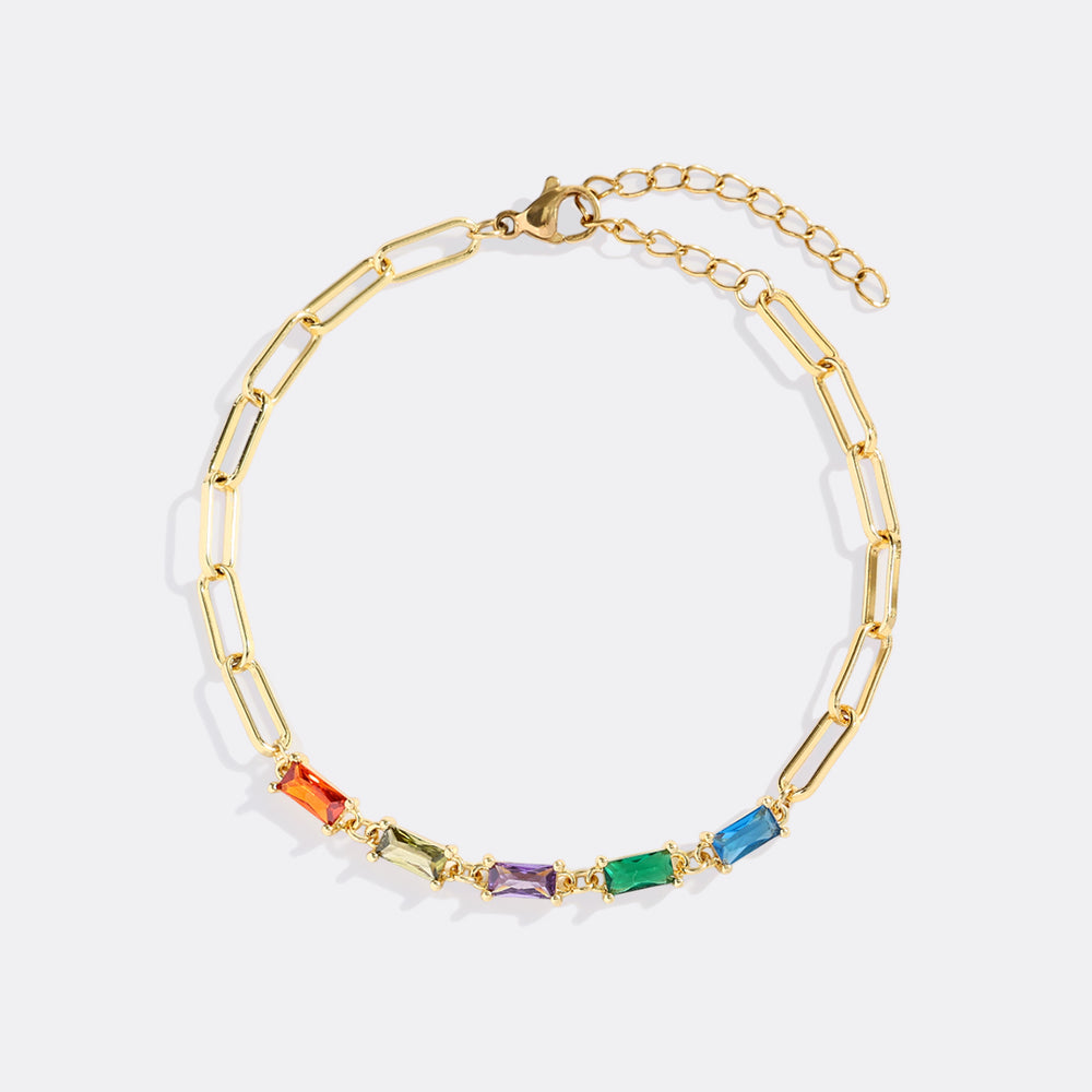 Gold bracelet with colorful gemstones on a white background