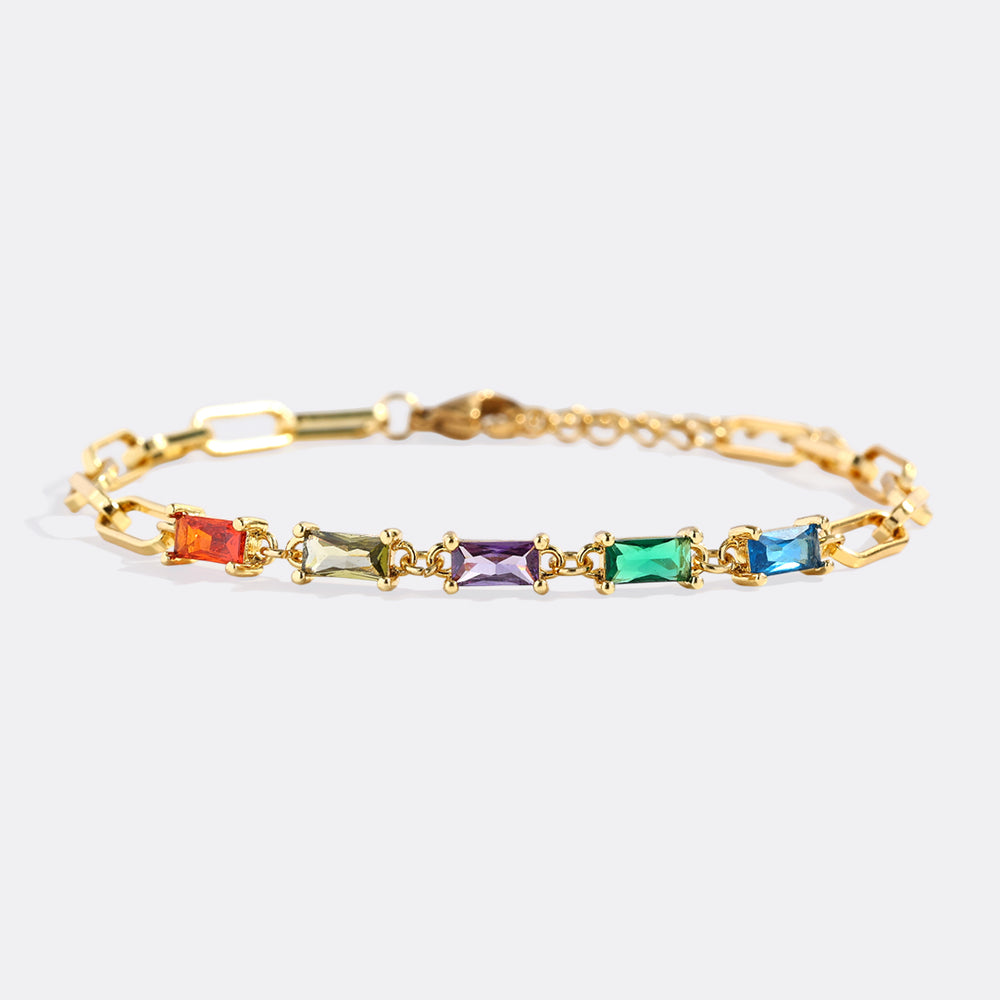 Gold bracelet with colorful gemstones on a white background