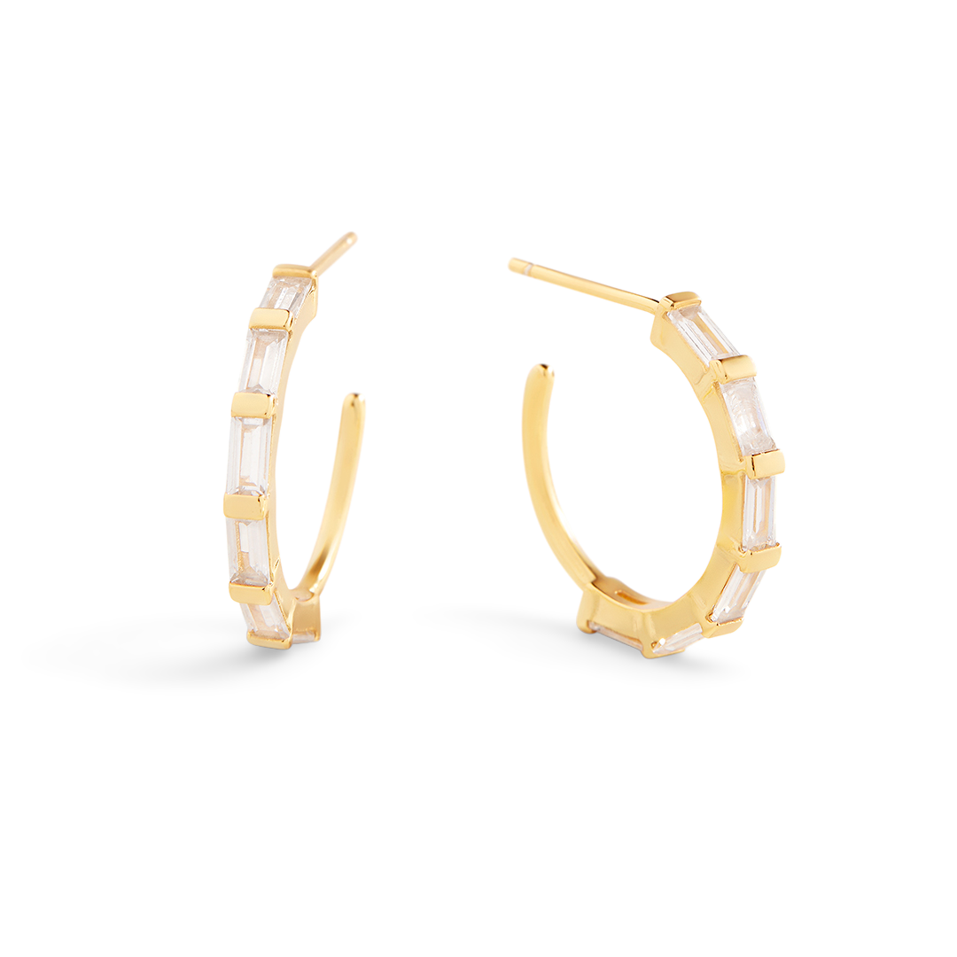 Gold hoop earrings with clear gemstones on a white background