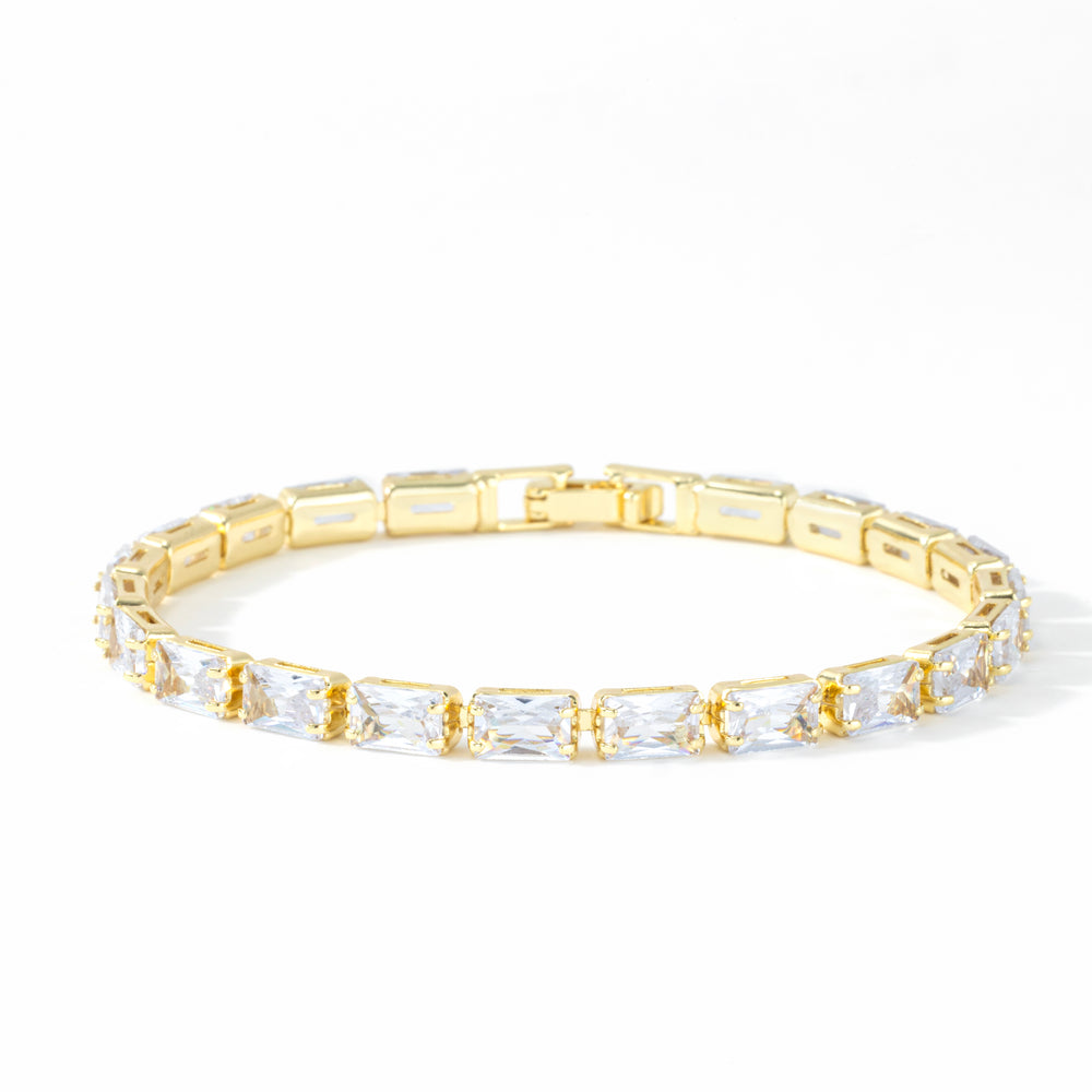 Gold baguette tennis bracelet with cubic zirconia stones on a white background