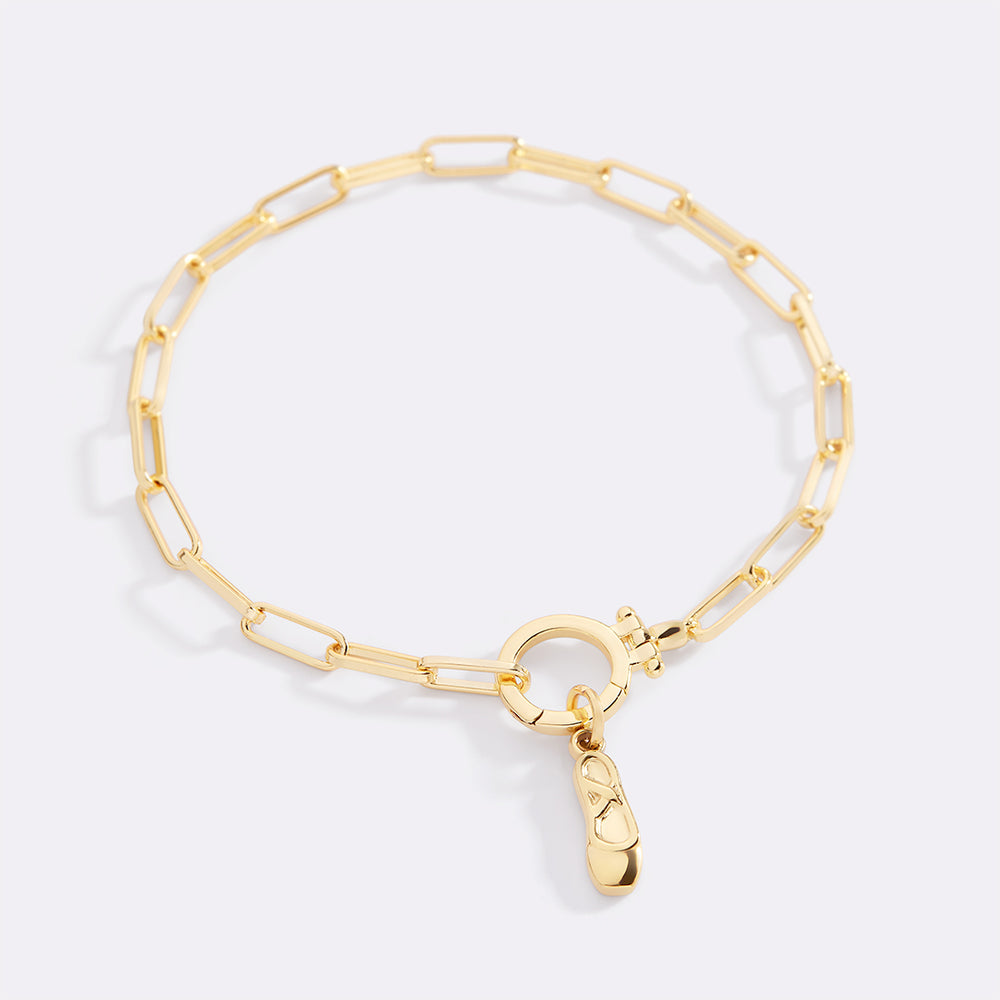 Gold bracelet with a heart-shaped clasp on a light gray background