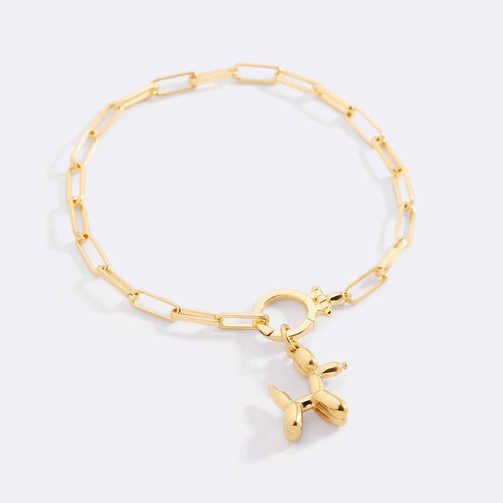 Gold bracelet with a unique charm on a light gray background