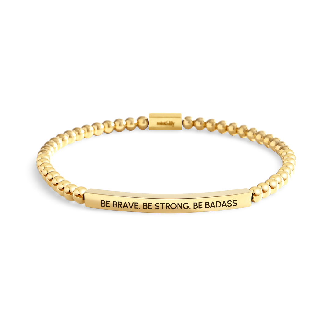 Gold bracelet with motivational message on a white background