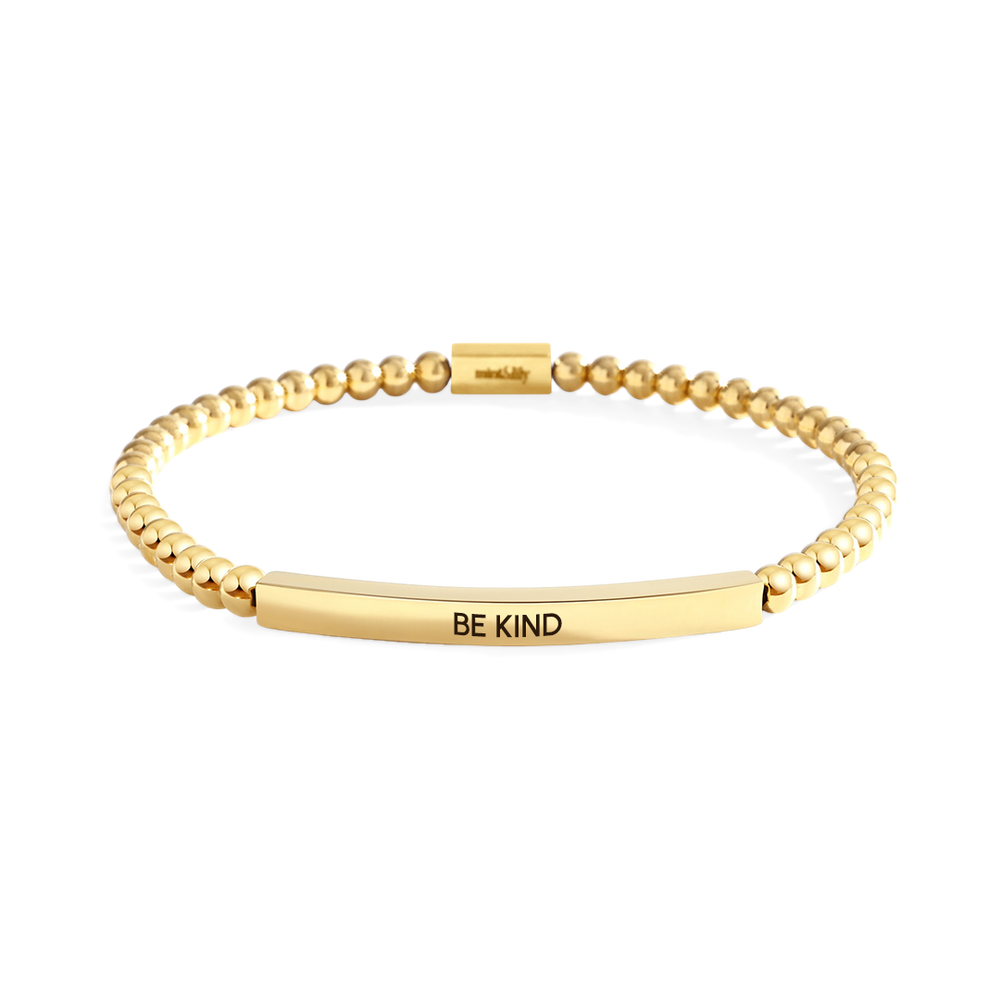 Gold bracelet with 'BE KIND' engraving on a white background