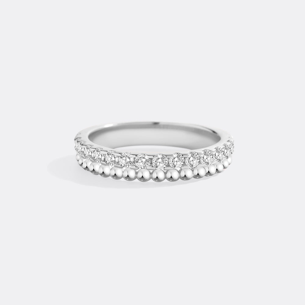 Silver ring with small diamonds on a light gray background