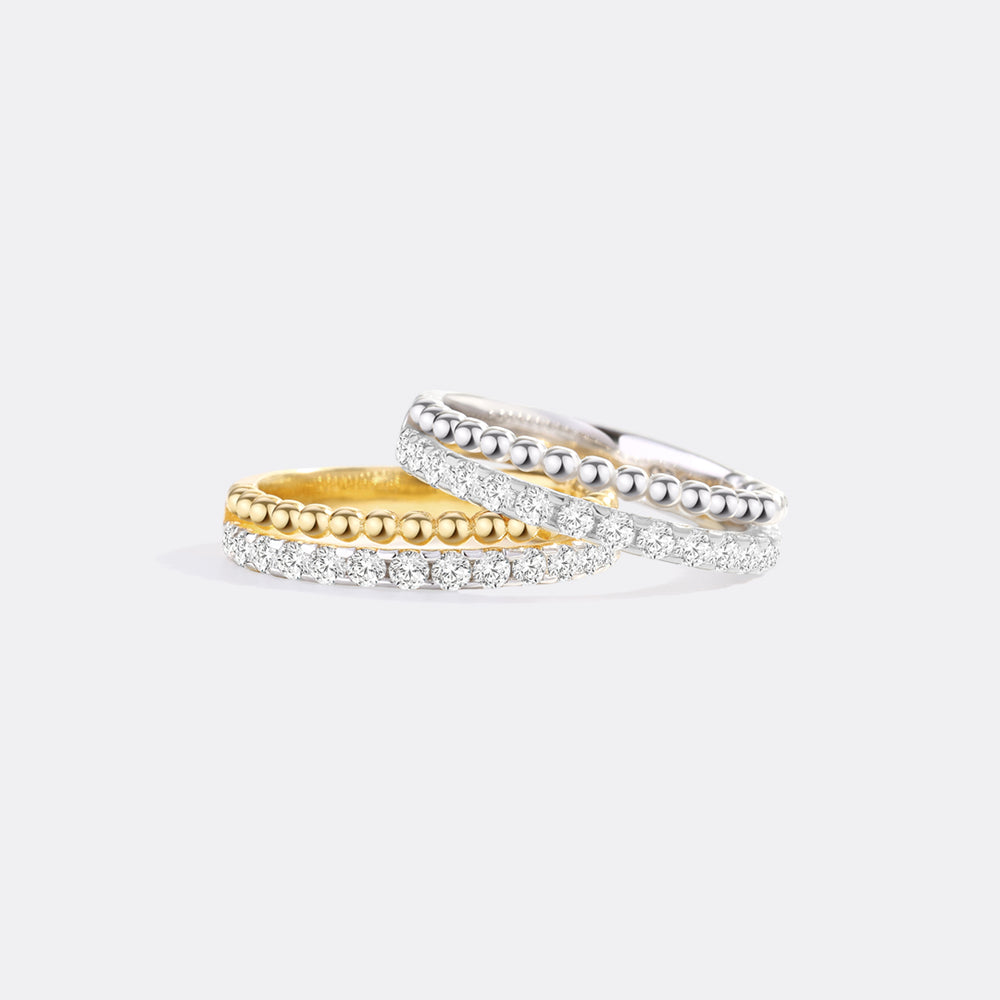 Two rings, one gold and one silver, on a light gray background