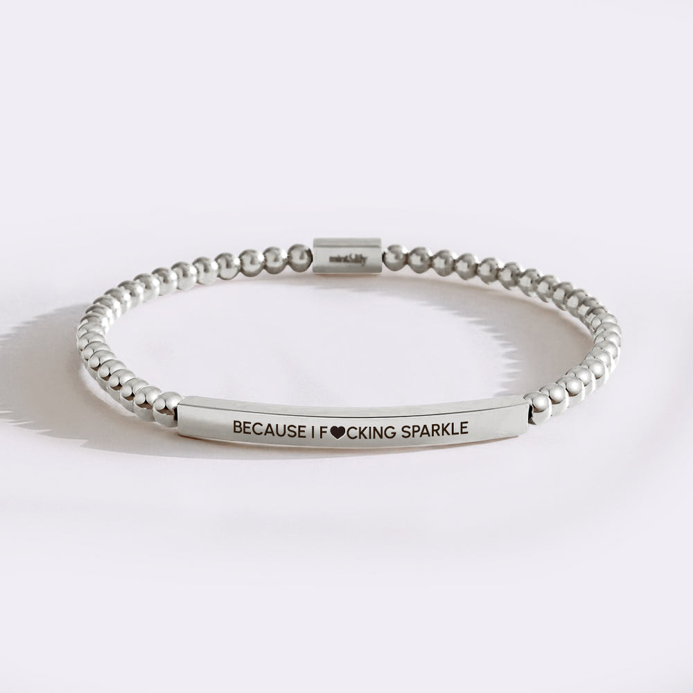 Silver beaded bracelet with engraved text on a white background