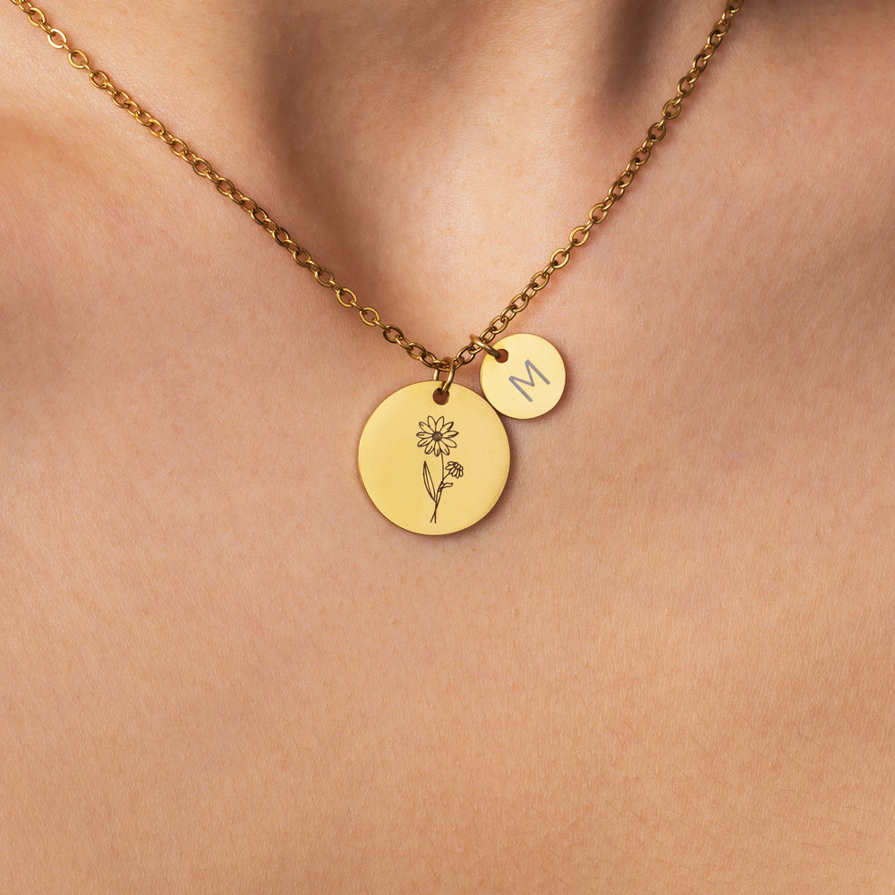 Model wearing the Birth Flower Initial Necklace, an engraved birth flower disc with a small initial disc on a fine chain.