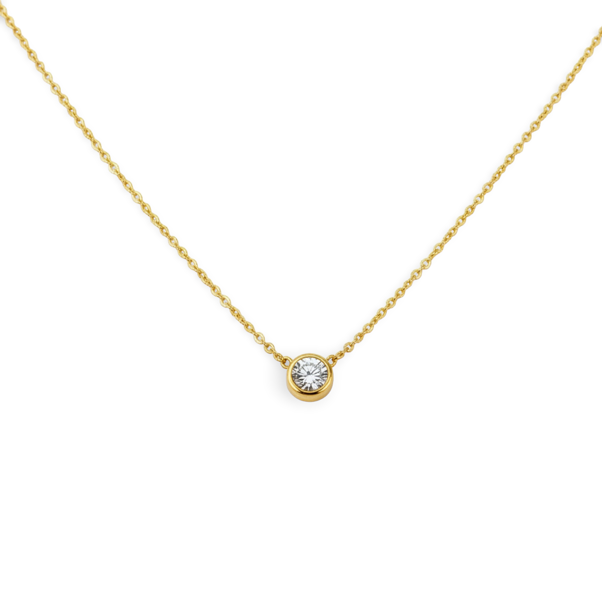 Gold necklace with a diamond pendant on a light gray background