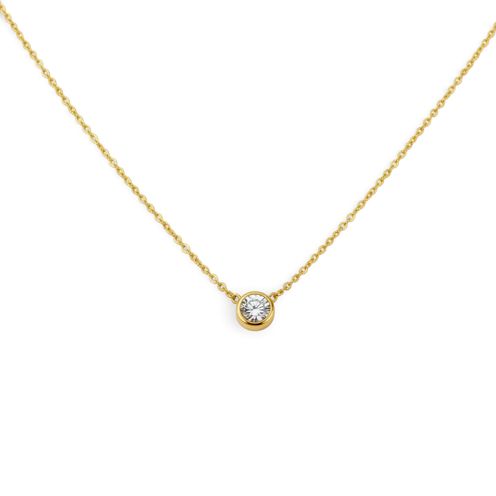 Gold necklace with a diamond pendant on a light gray background