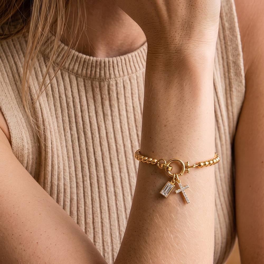Model wearing the Cross Charm Birthstone Bracelet with April diamond-look crystal birthstone charm on her wrist.
