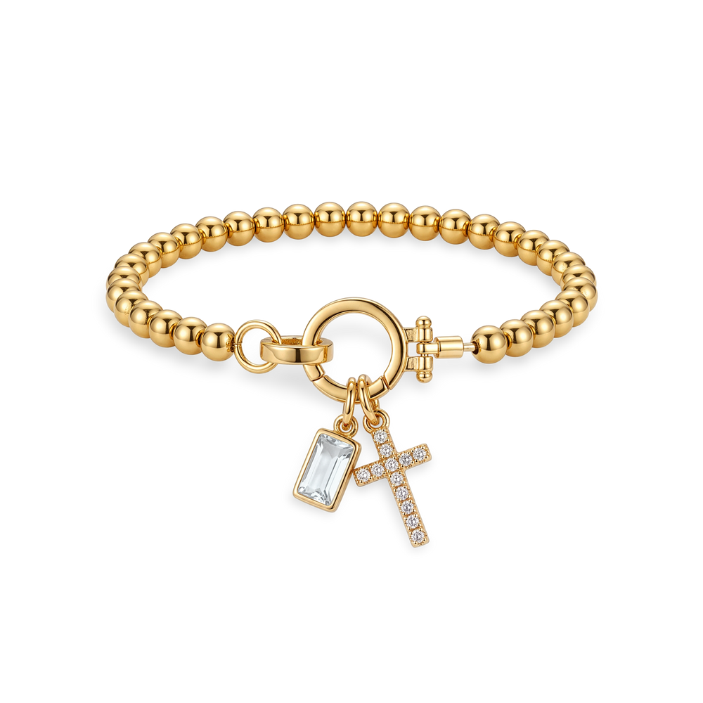 Flat lay of the Cross Charm Birthstone Bracelet with April diamond-look crystal birthstone charm.