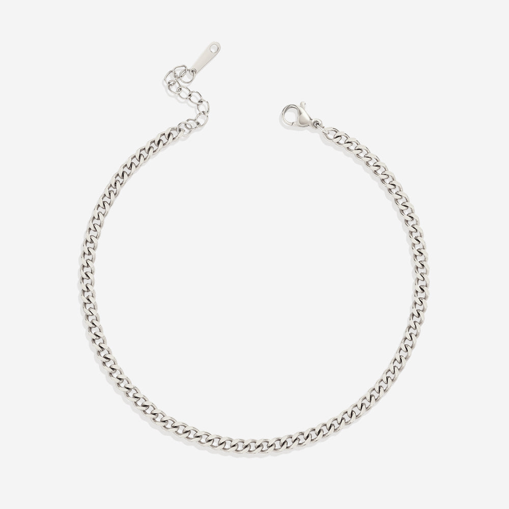 A gold curb chain anklet on a white background.