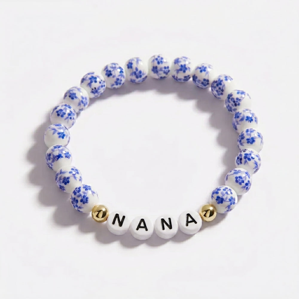 Bracelet with blue floral beads and 'Nana' charm on a white background