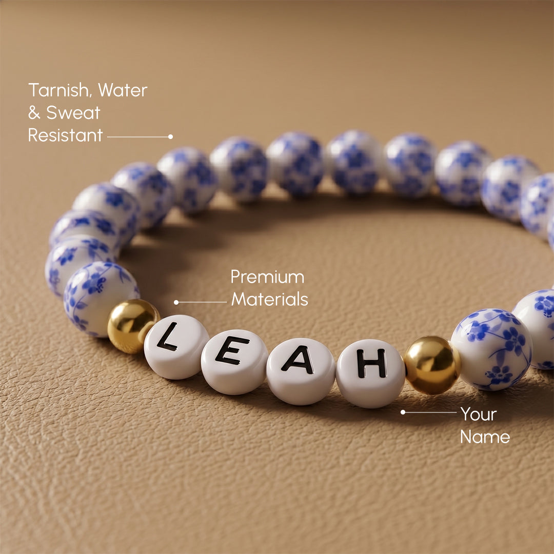 Bracelet with white beads labeled 'LEAH' on a beige background