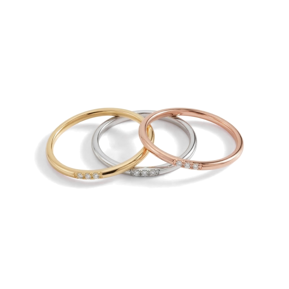 Three gold, silver, and rose gold bangles on a light gray background