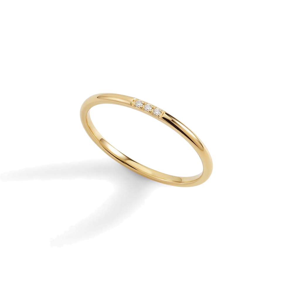Gold ring with small diamonds on a light gray background