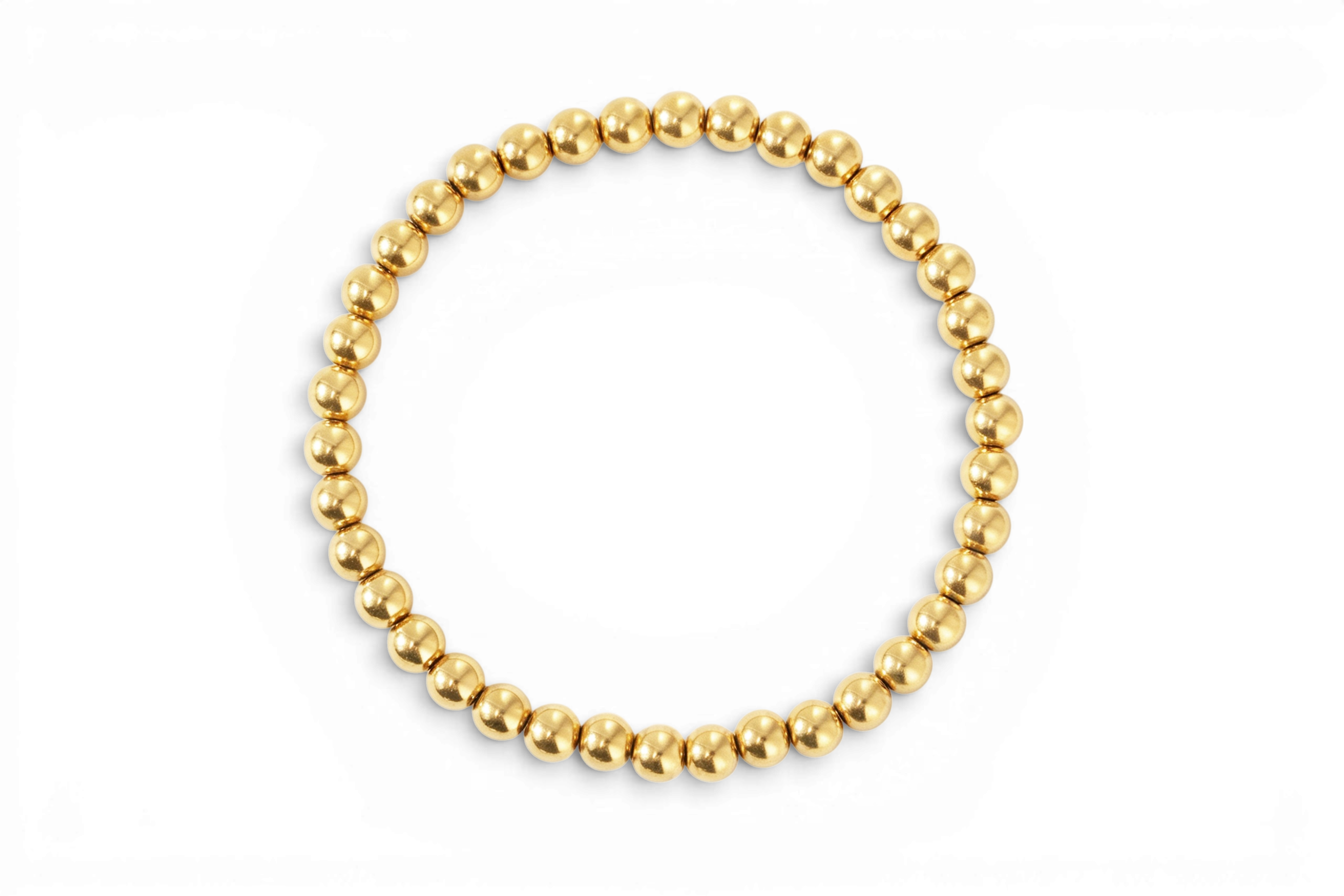 Dainty gold beaded bracelet on a white background