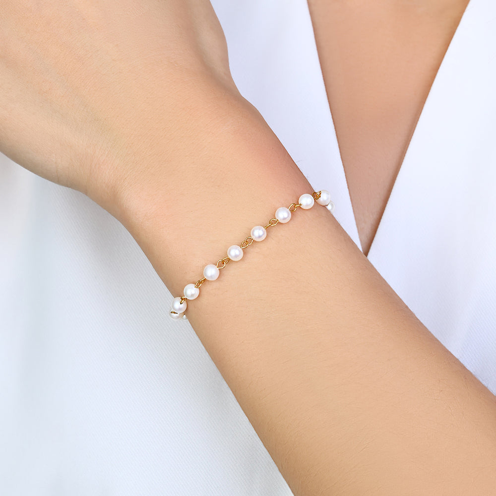Pearl bracelet on a person's wrist against a white background