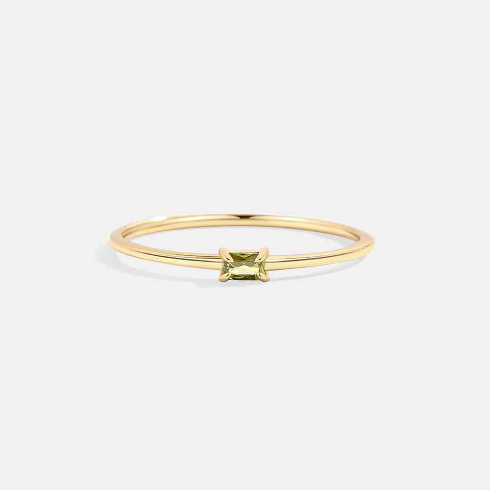Gold ring with a green gemstone on a white background