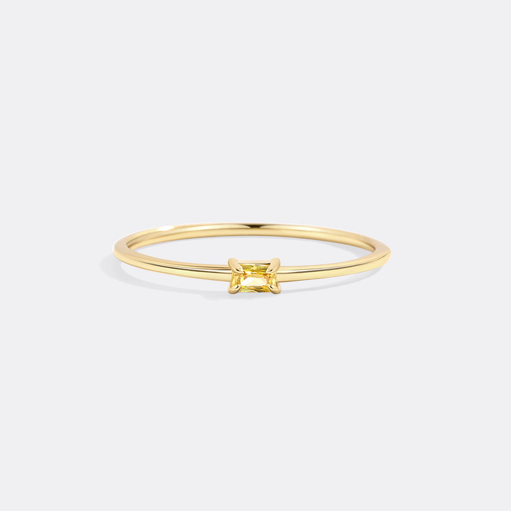 Gold ring with a square-cut gemstone on a white background
