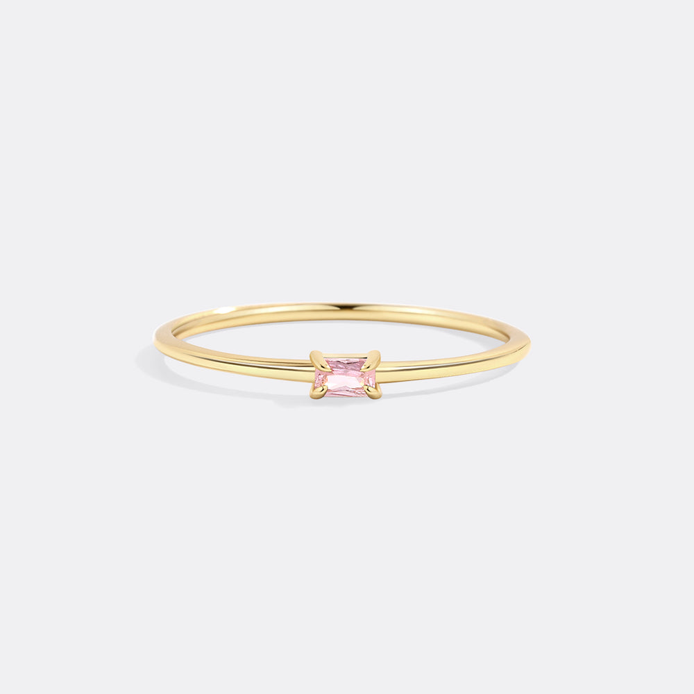 Gold ring with a pink gemstone on a white background