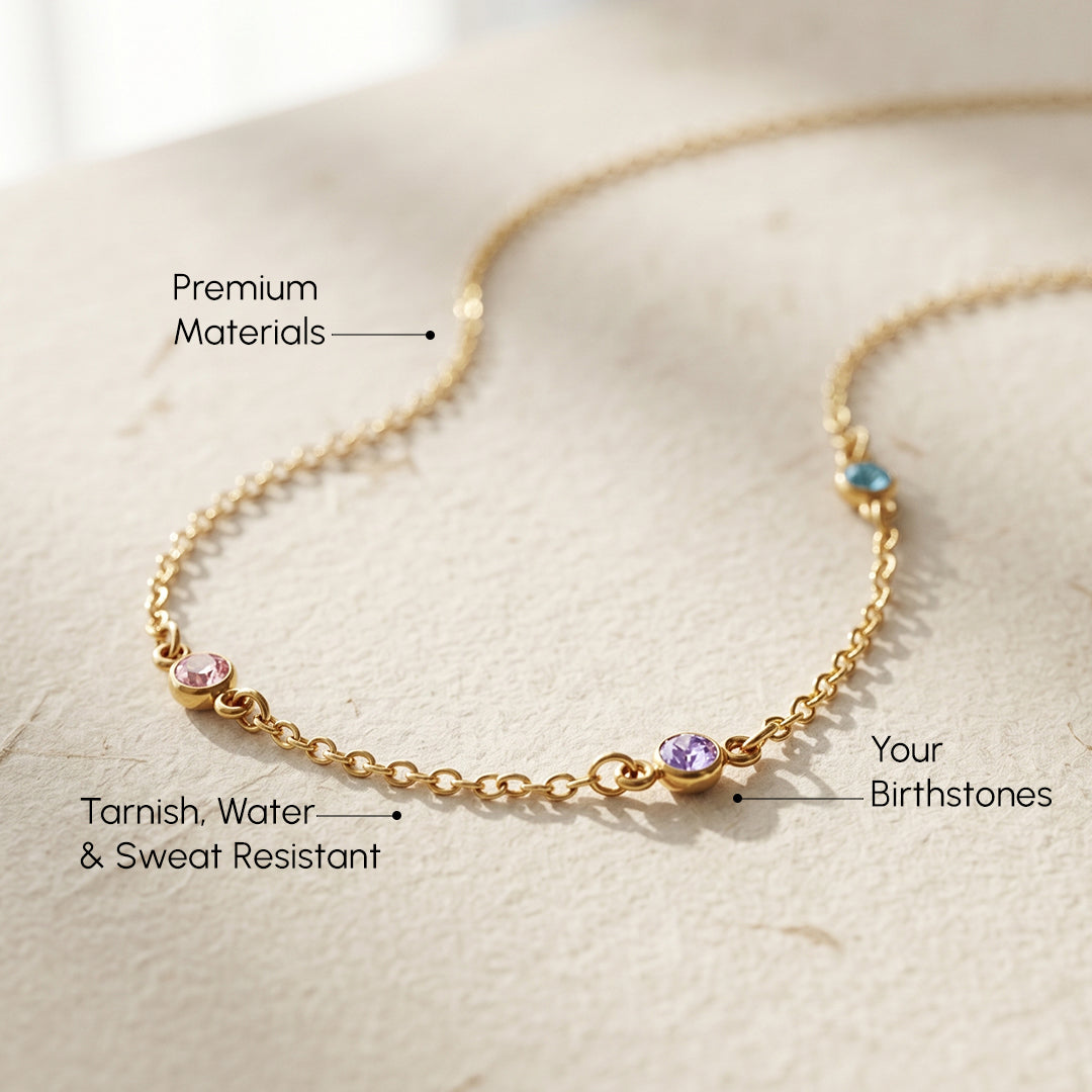 Gold necklace with birthstones on a light background