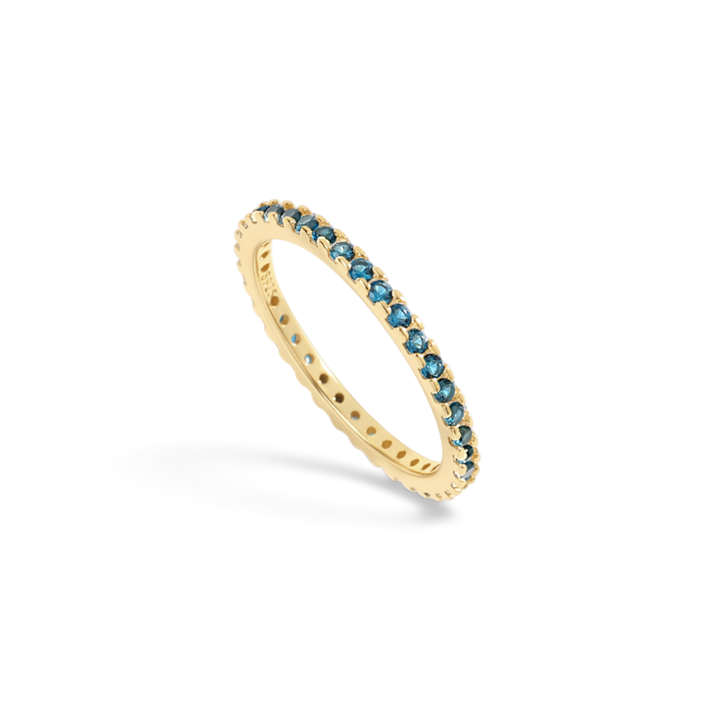 Gold ring with blue gemstones on a light gray background