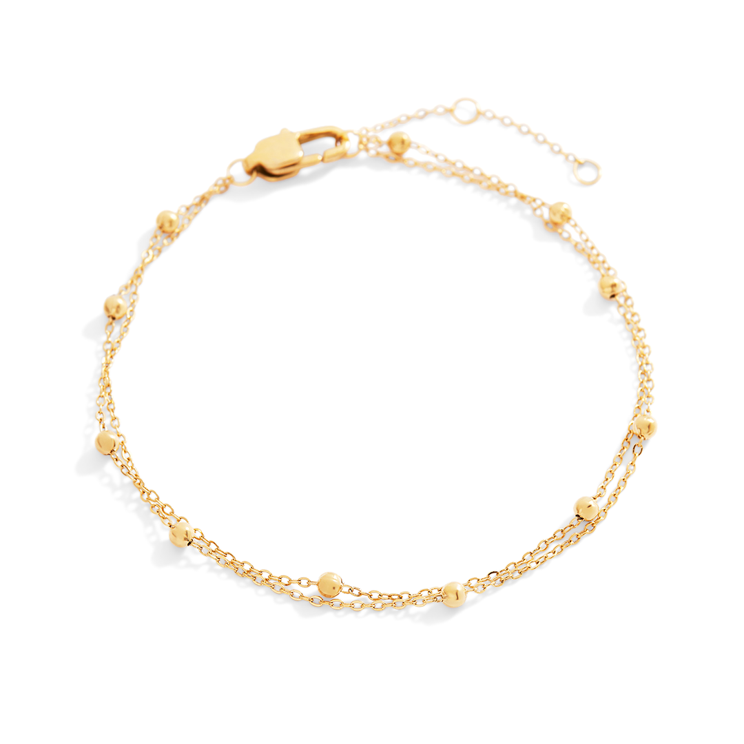 Gold bracelet on a light gray background