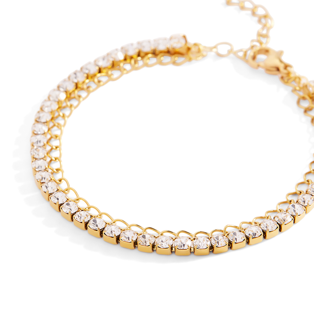 Gold bracelet with clear gemstones on a light gray background