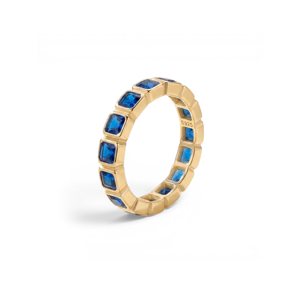 Gold ring with blue gemstones on a white background