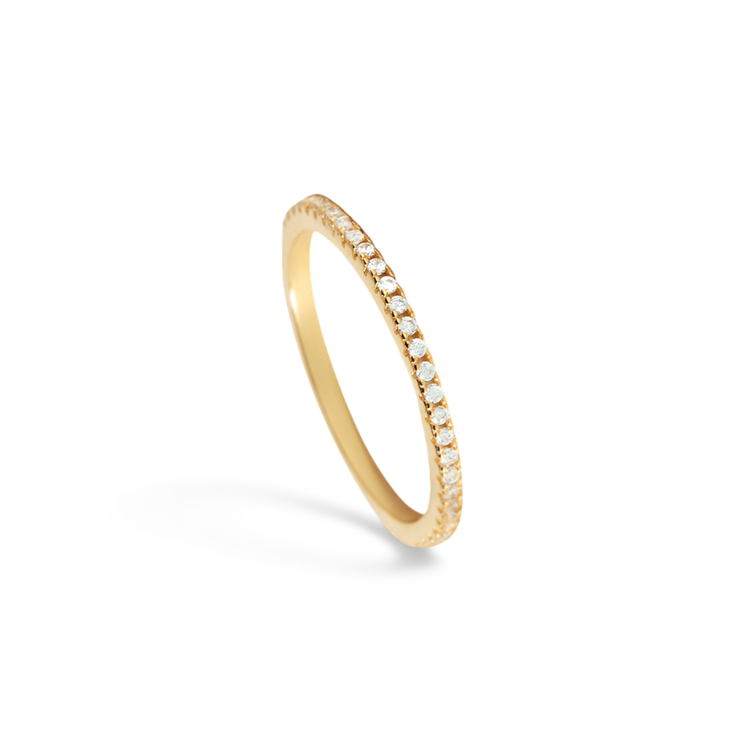 Gold ring with small diamonds on a light gray background