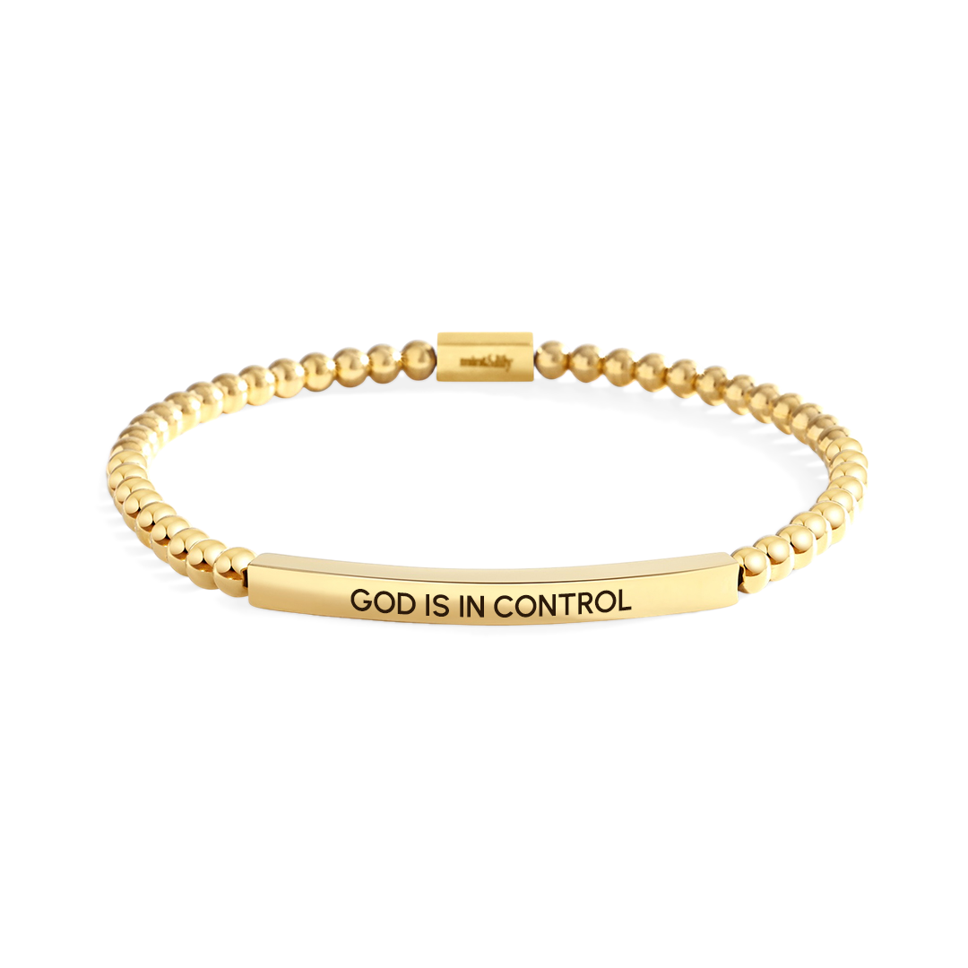 Gold bracelet with 'GOD IS IN CONTROL' engraving on a white background