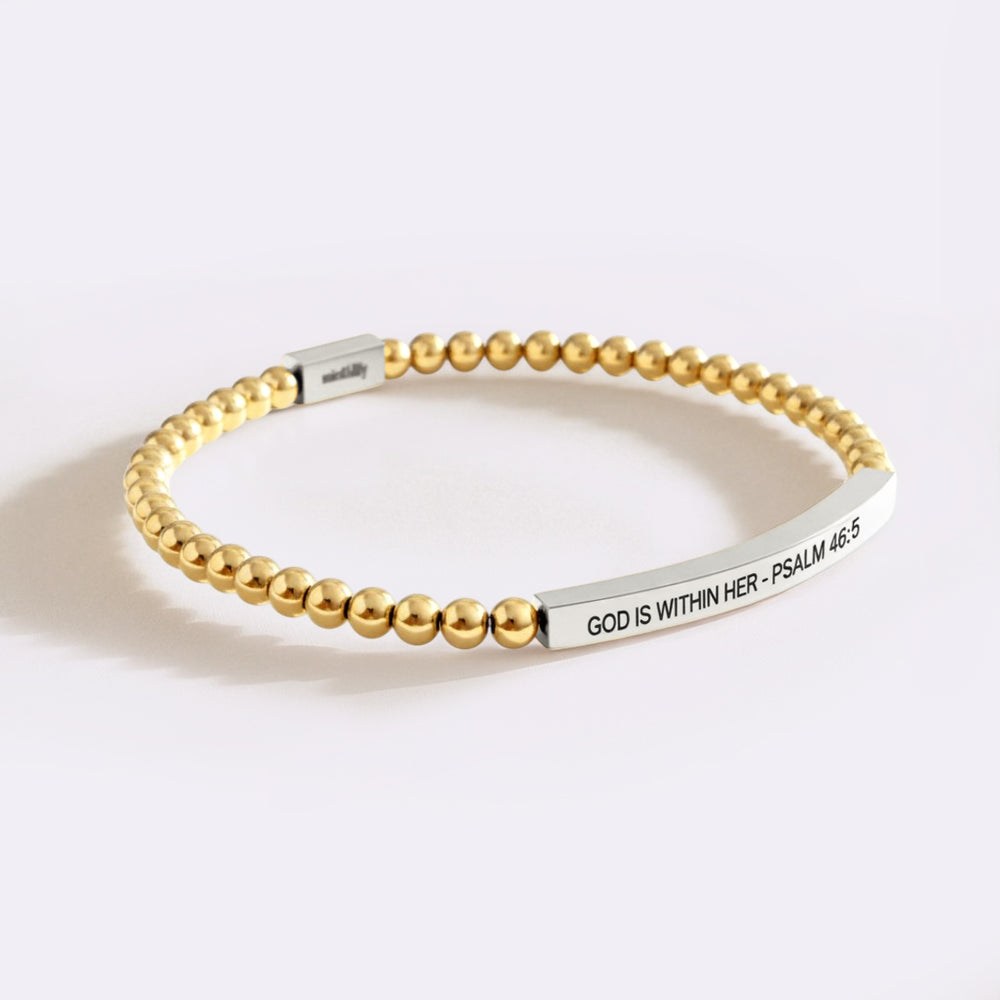Gold beaded bracelet with engraved message on a white background