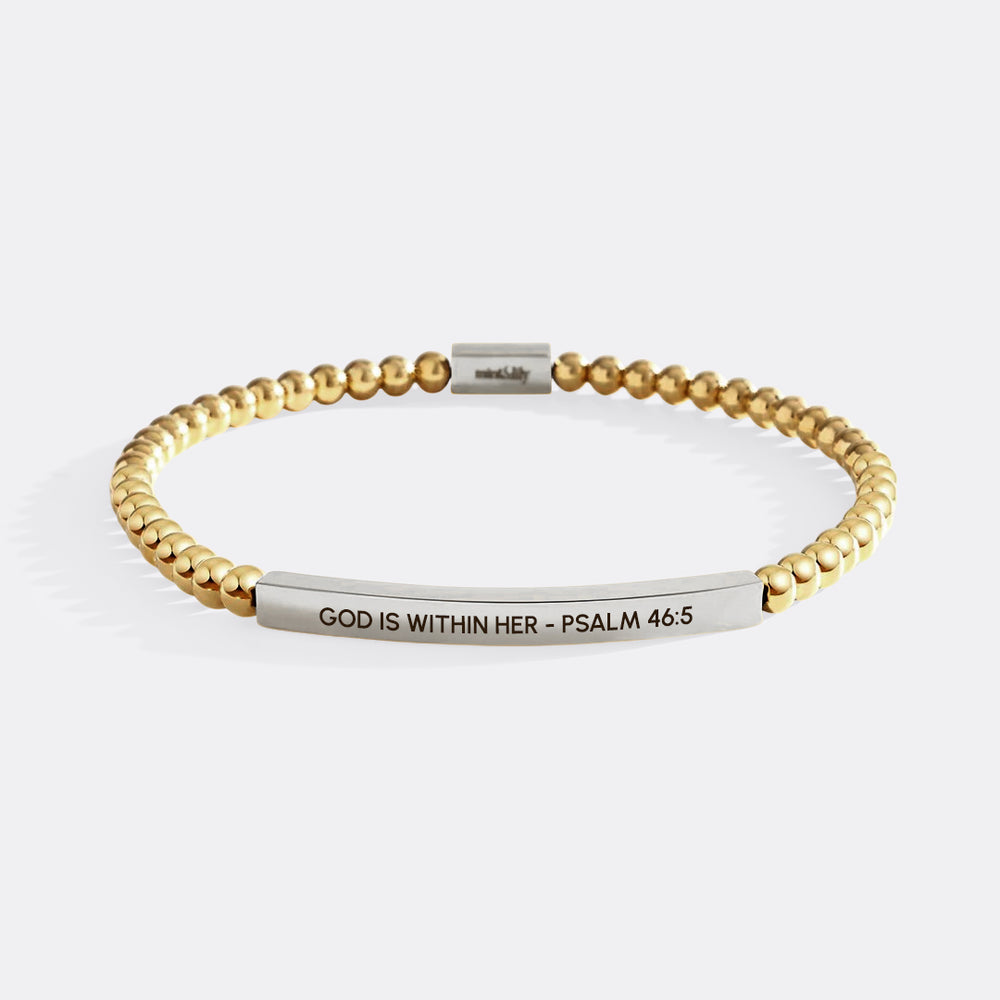 Gold and silver bracelet with engraved text on a white background