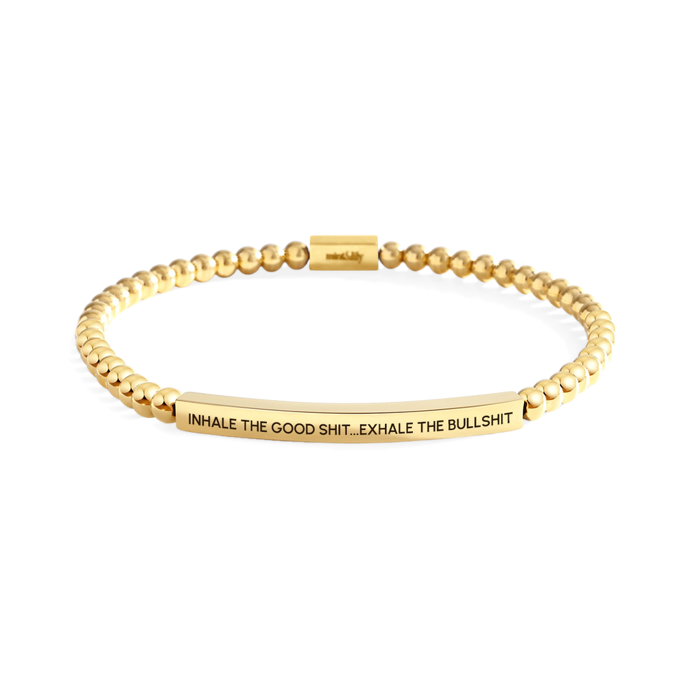 Gold beaded bracelet with engraved text on a white background