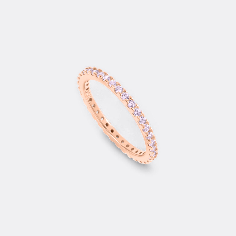 Rose gold ring with small diamonds on a light gray background