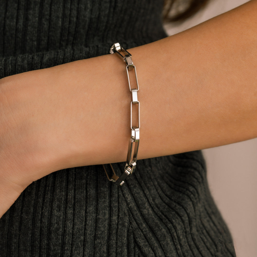 Silver chain bracelet on a person's wrist with a blurred background
