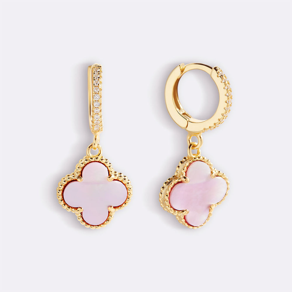 Gold and pink earrings on a white background