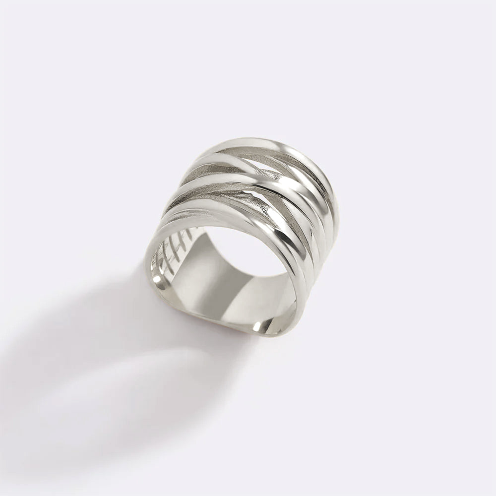 Silver ring with wavy design on a white background